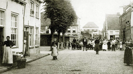 <p>Ansichtkaart van rond 1900 (vóór 1902). De foto is genomen vanuit de Lievevrouwestraat richting de Tengnagelshoek. In de verte is de in 1842 gebouwde pastorie herkenbaar als een statig neoclassicistisch herenhuis. (RAZ beeldbank)</p>
